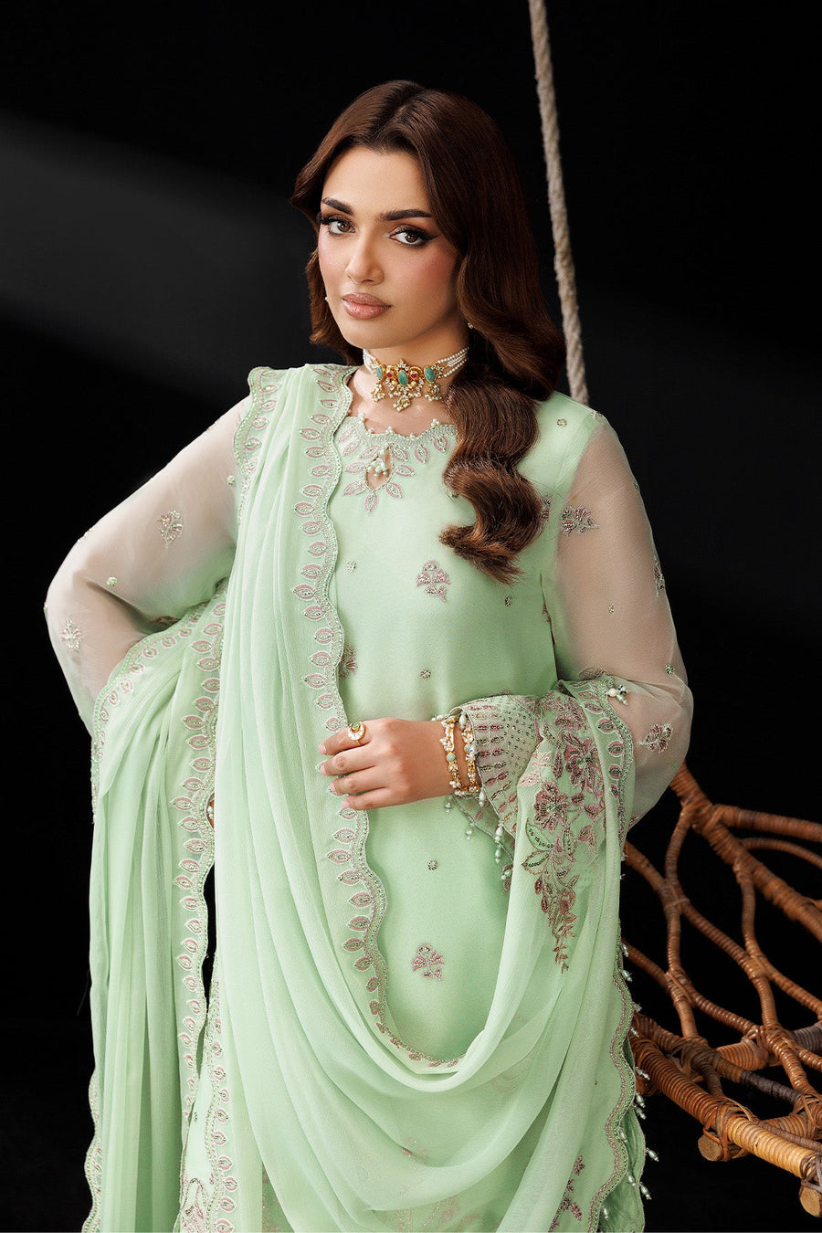 Back angled view emphasizing flared trousers and embroidery along hemline