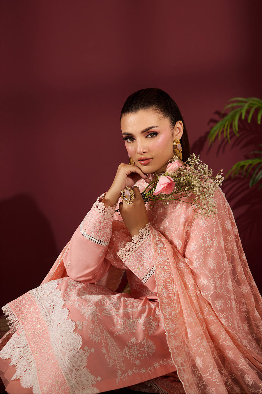 Close-up portrait of woman in embroidered lawn suit holding flowers