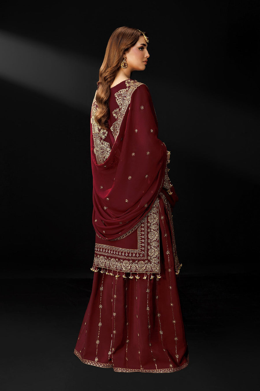 Back view of maroon traditional suit showcasing embroidery on dupatta and flared trousers