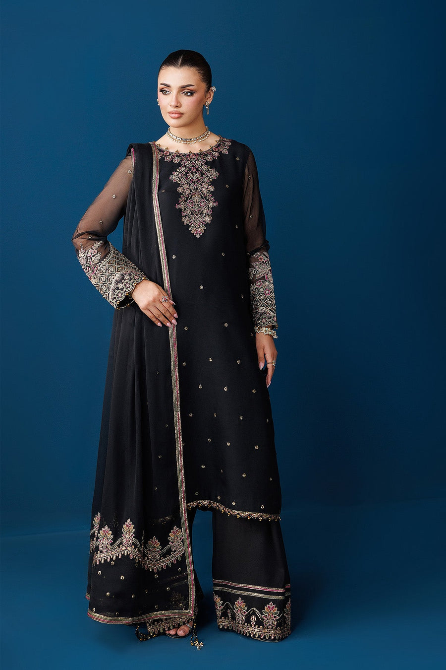 Front view of black chiffon suit highlighting embroidered neckline and sheer sleeves