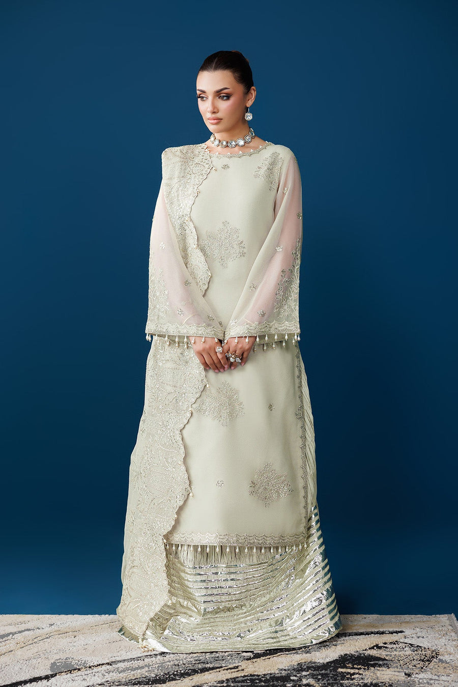 Front view of woman wearing embroidered chiffon semi-formal dress with sheer sleeves and silver-striped raw silk trouser