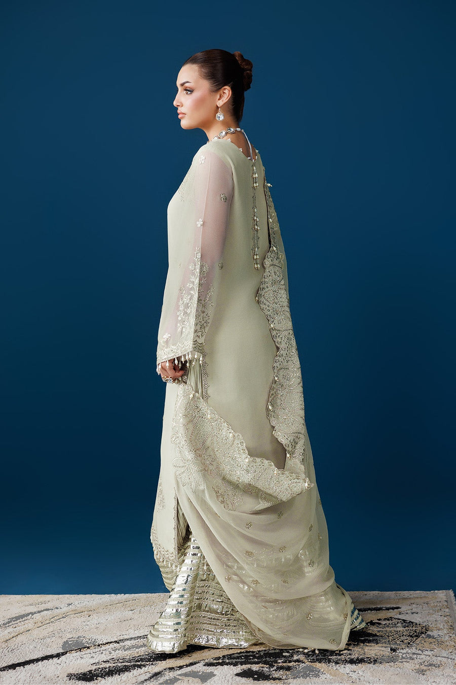 Side view showing intricate embroidery and scalloped edges on chiffon dress and dupatta