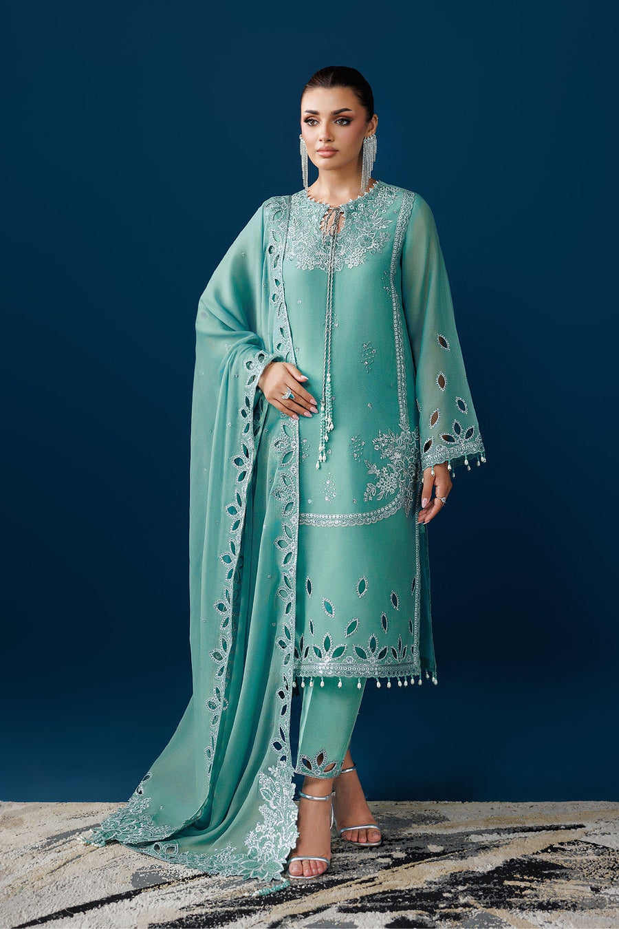 Front view of embroidered sea glass green Pakistani suit with pearl tassels and detailed cutwork on sleeves and hem