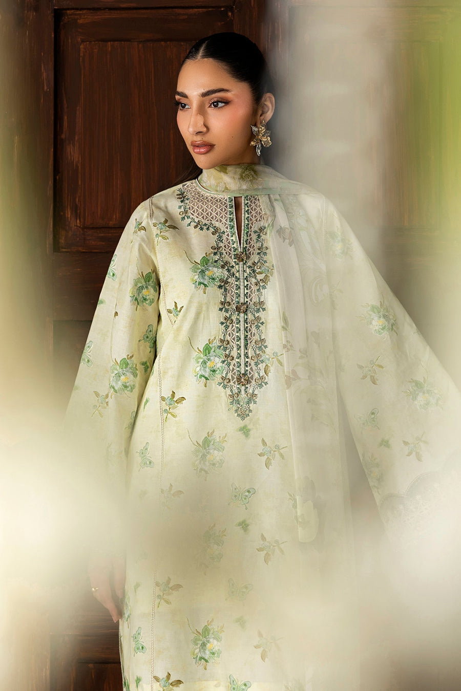 Elegant close-up of embroidered neckline with floral needlework and decorative buttons