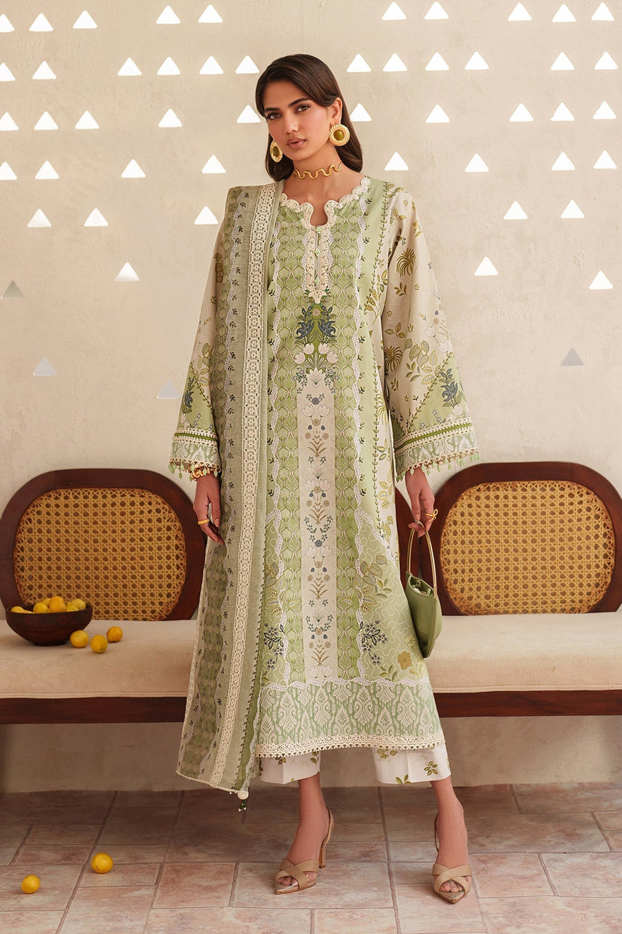 Front view of woman wearing embroidered lawn shirt with coordinating dupatta and trousers, beige heeled sandals, and gold jewelry