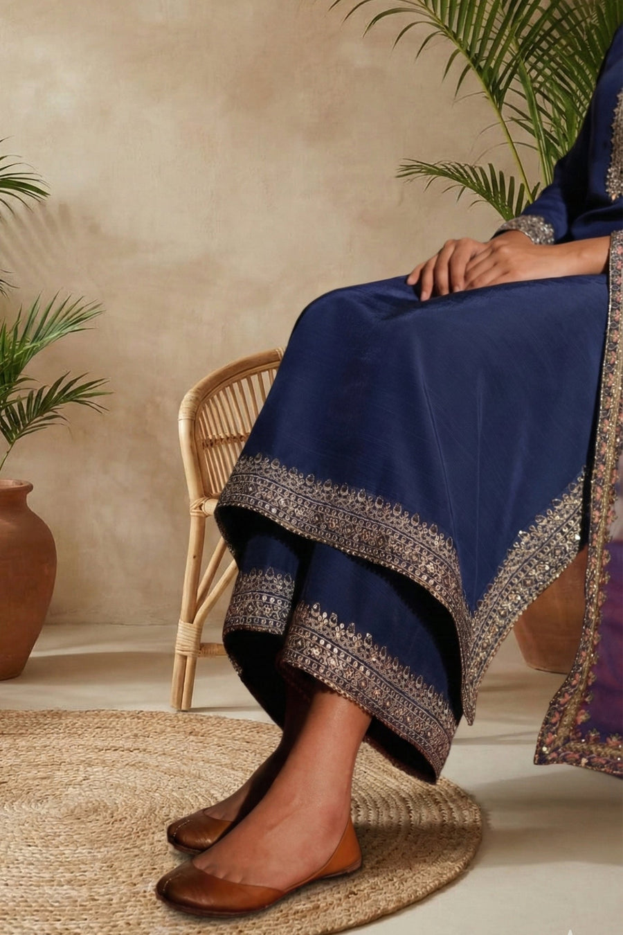 Woman modeling sheer embroidered dupatta over blue kameez in elegant setting