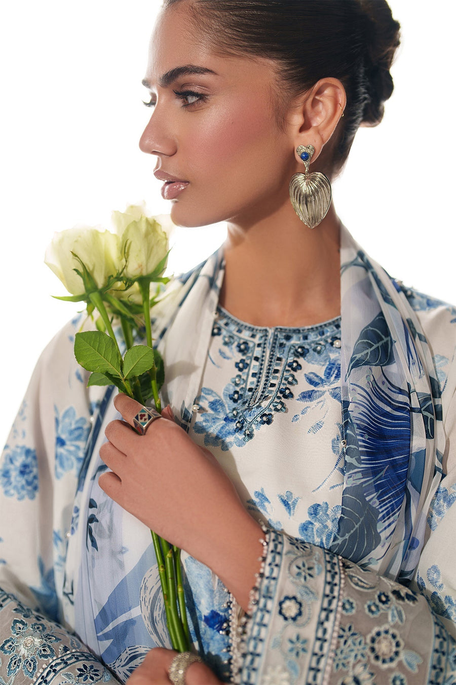 Detailed shot of embroidered cuff with floral motifs and delicate beadwork on the tunic sleeve