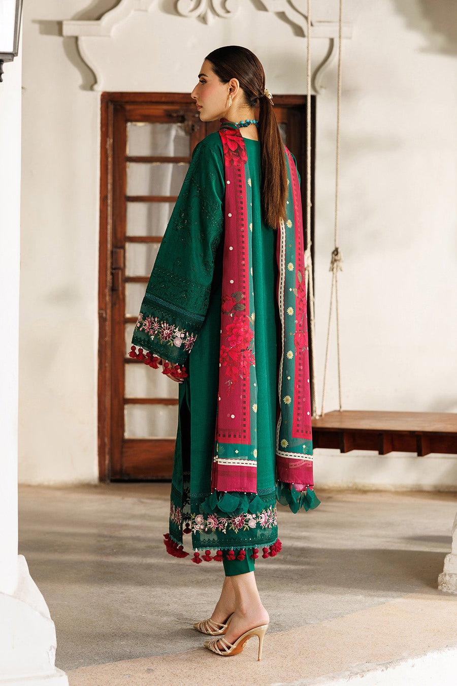 Back view of woman in embroidered green lawn suit showing intricate embroidery and floral chiffon dupatta