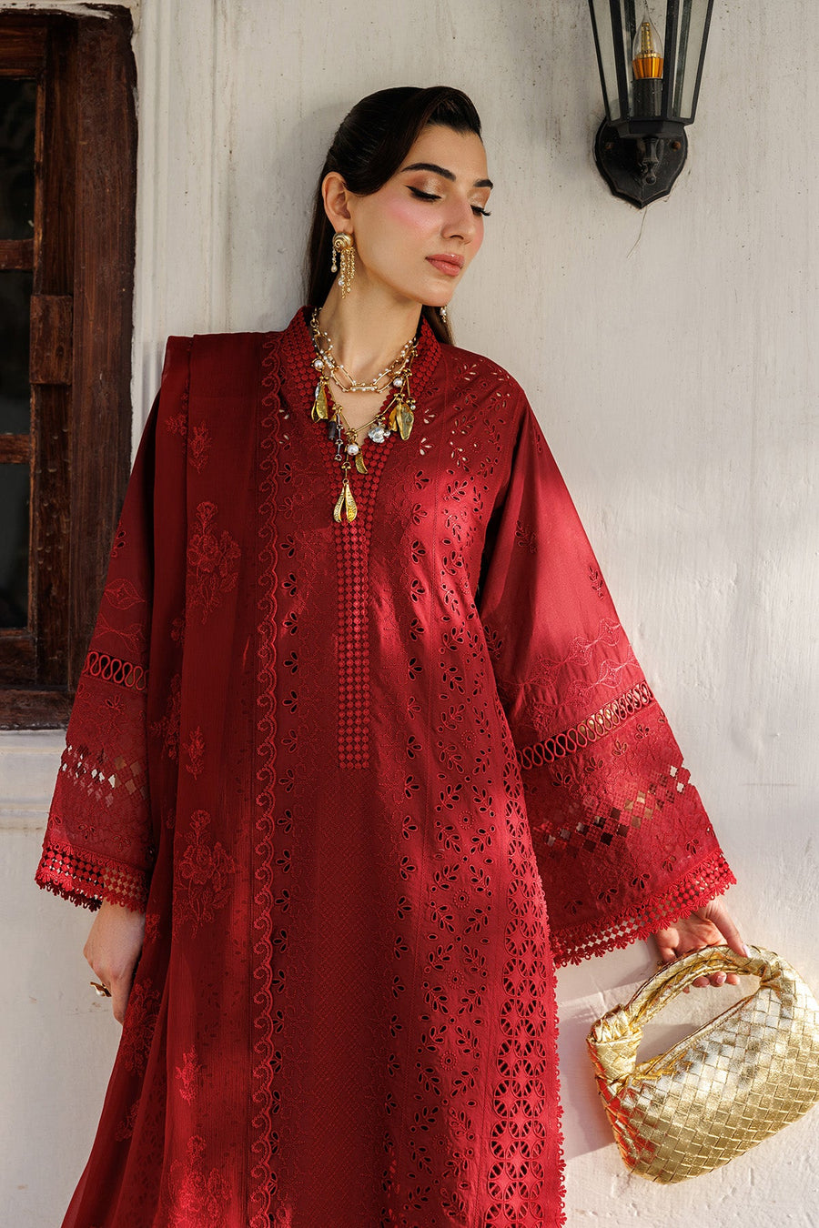 Close-up of embroidered neckline and sleeve details on red lawn suit with gold jewelry