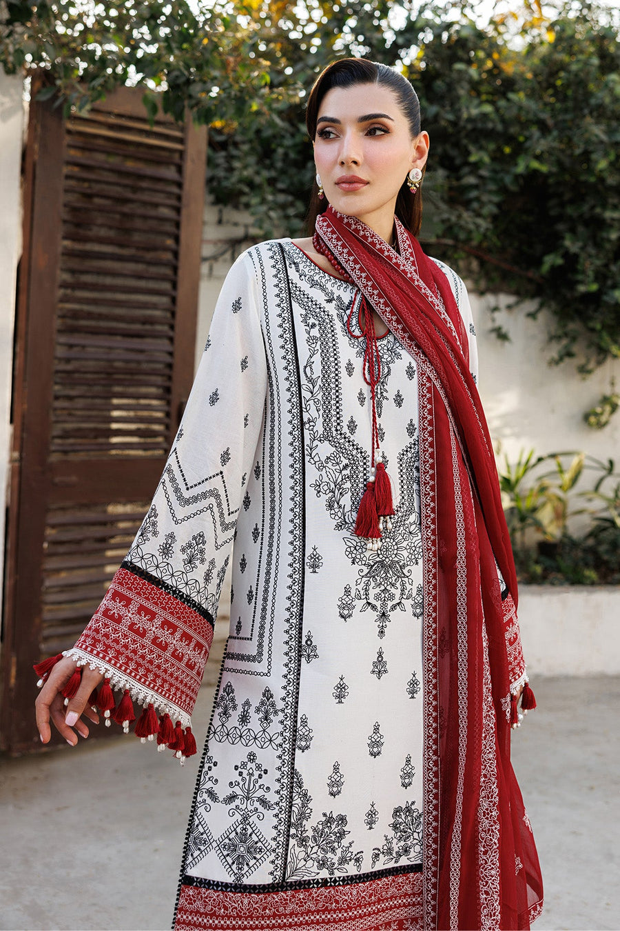 Close-up side view of embroidered lawn suit with detailed black motifs on white shirt