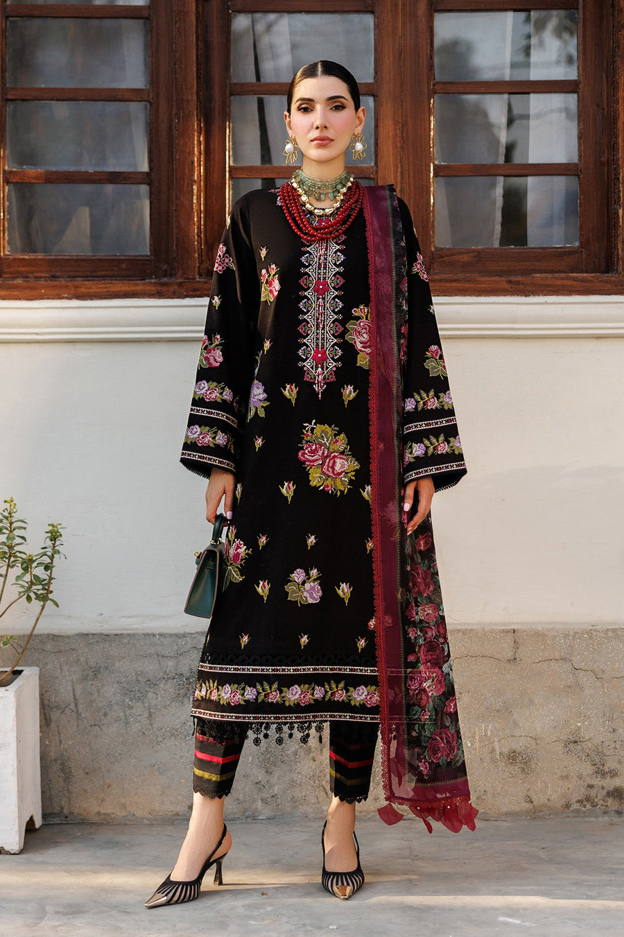 Front view of embroidered floral lawn suit with black base and colorful floral embroidery, paired with a printed chiffon dupatta and striped trousers