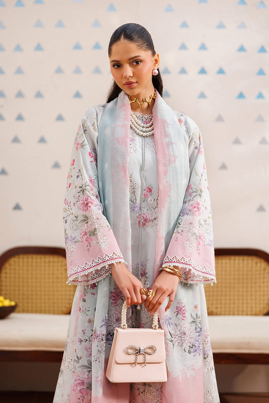 Close-up of embroidered lawn suit hem featuring intricate lace detail and butterfly embroidery, paired with delicate cutwork white pants and beige pointed shoes