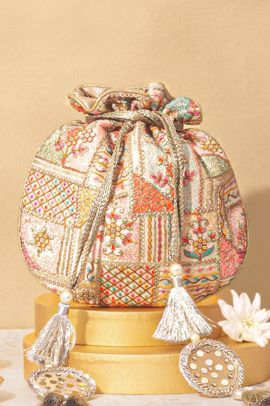 Colorful embroidered potli bag with drawstring tassels featuring pearl and metallic accents