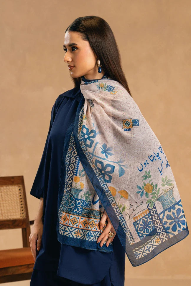 Woman wearing an elegant printed Swiss lawn scarf with blue, yellow, and cream floral and geometric patterns over a navy outfit.