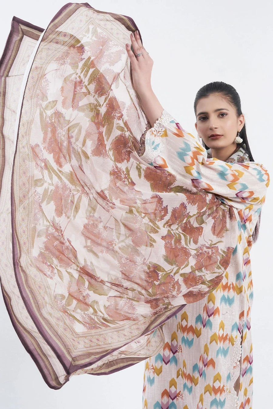 Close-up of the sheer chiffon dupatta with floral print and decorative border held up by a woman
