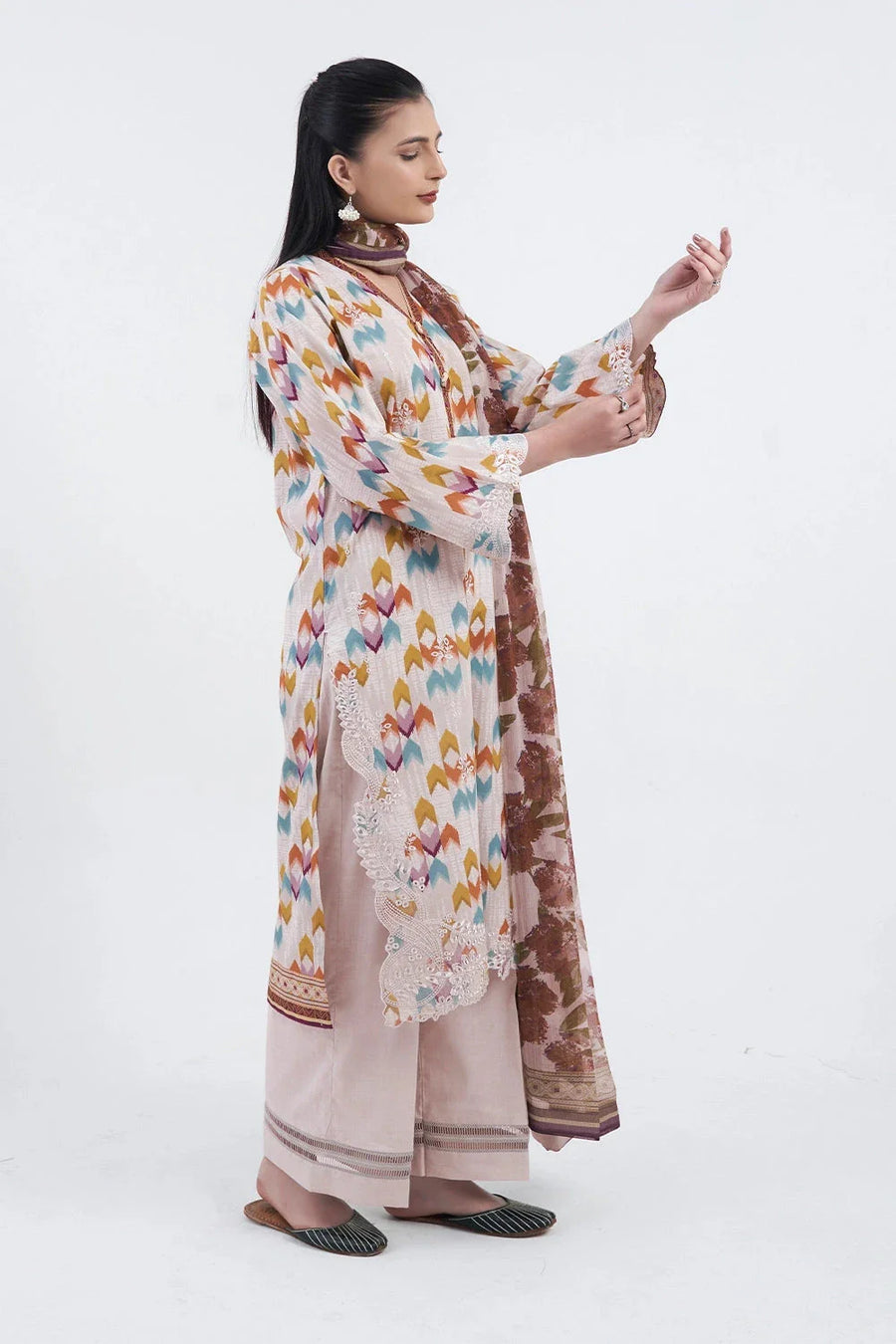 Side view of the model wearing the three-piece lawn suit showing loose trousers and dupatta draped over shoulder