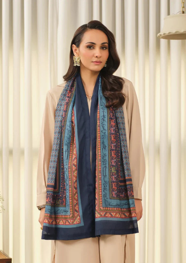 Woman wearing a navy blue and multicolor printed Swiss lawn scarf featuring Urdu calligraphy over a beige outfit