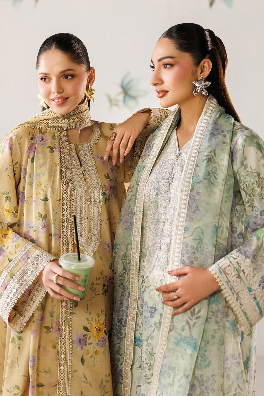 Close-up of hands and sleeves reaching for a green smoothie on a minimalist black table, emphasizing fabric details