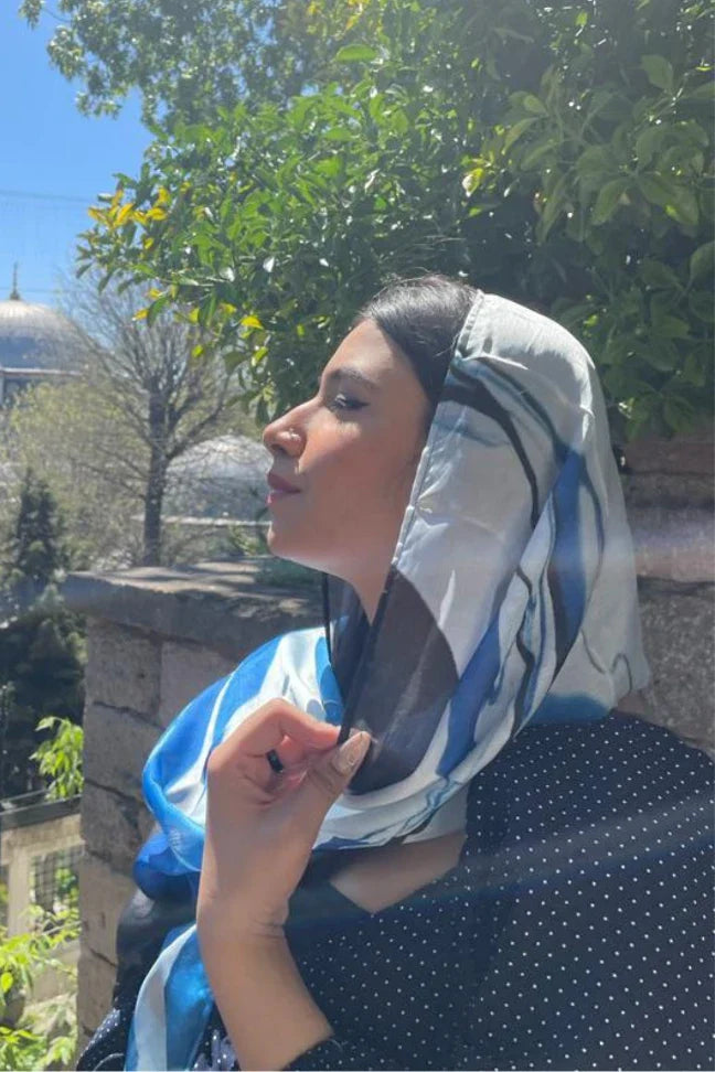 Woman outdoors wearing Qudrat Samandar Blue luxury crinkle silk scarf with embroidered design