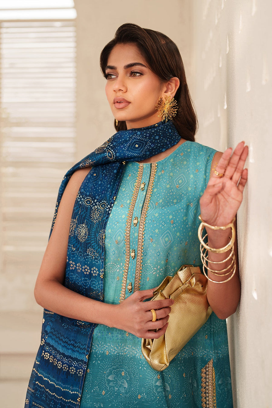 Close-up of the embroidered gold motif on the back of the teal part of the lawn suit alongside detailed printed dupatta