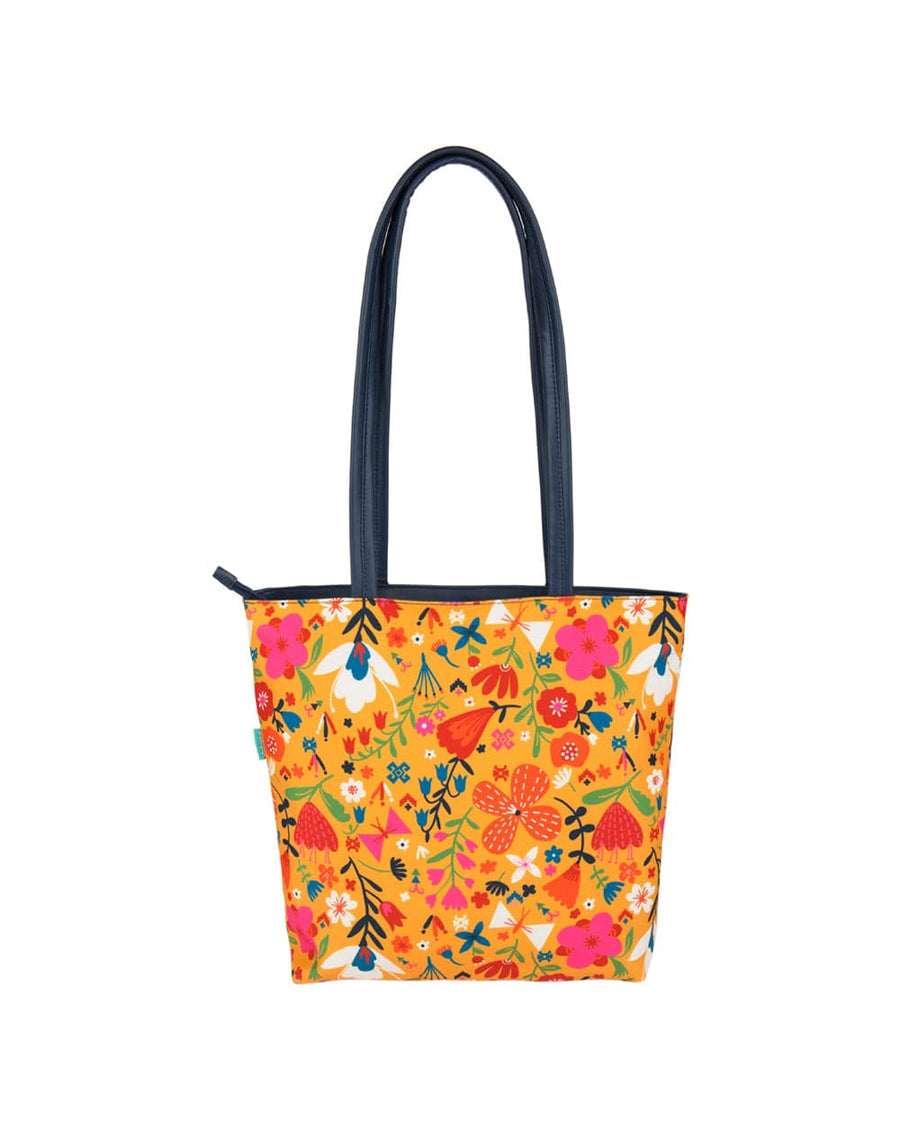 Back view of tote bag in bright orange with floral prints and navy blue handles