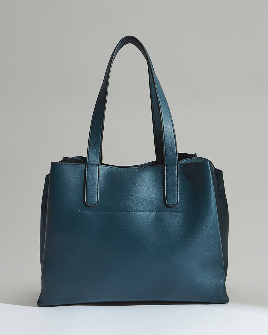 Close-up showing the smooth texture of the vegan leather with embroidery and gold hardware