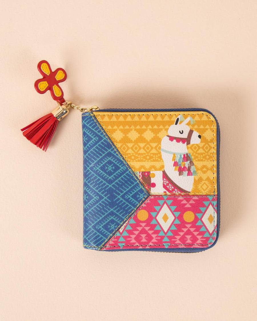 Colorful embroidered ethnic wallet with llama motif, geometric patterns, and red tassel on a neutral background