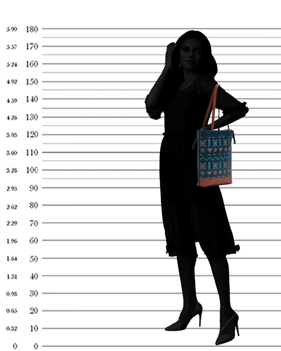 Silhouette of woman holding the navy embroidered tote bag by the straps over her shoulder