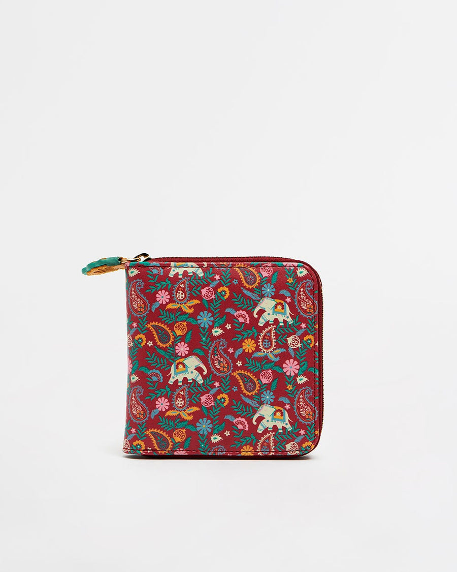 Compact mini wallet in red with multicolored paisley and elephant designs, secured with zip closure and decorative pull tab