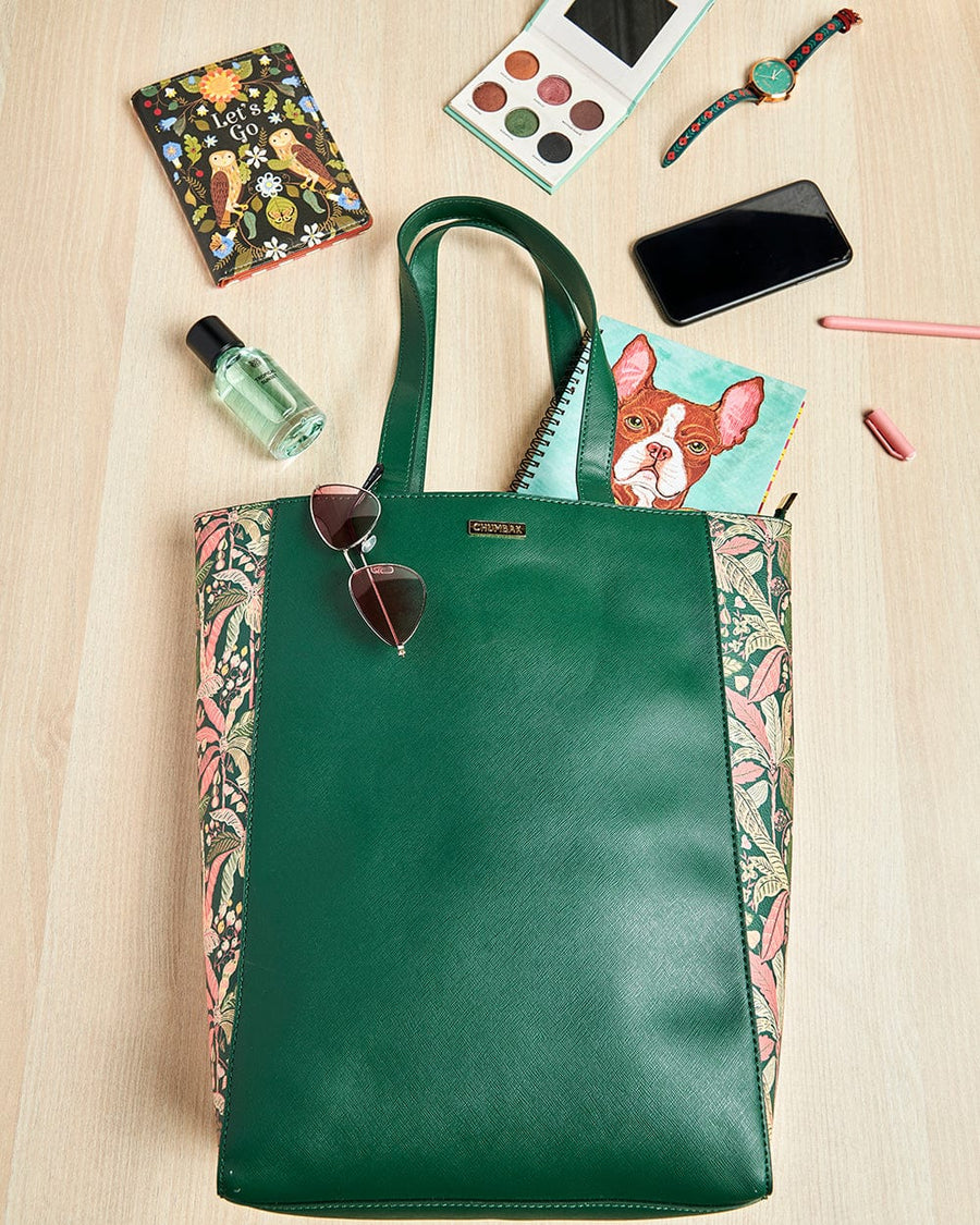 Flat lay image of Palm Springs tote bag surrounded by personal items like cosmetics, watch, phone, notebook, and sunglasses