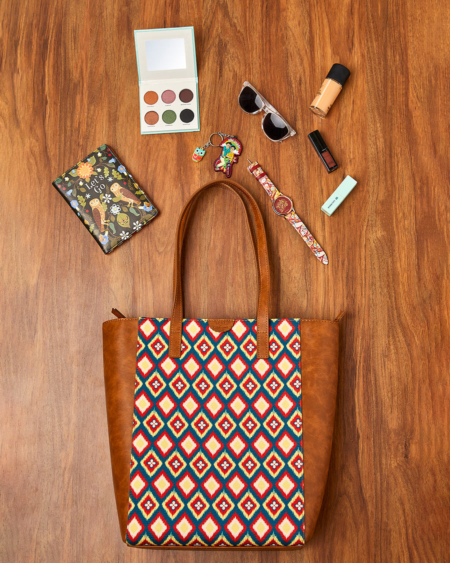 Teal by Chumbak tote bag surrounded by everyday essentials including sunglasses, makeup, wallet, watch and keychains on wooden surface