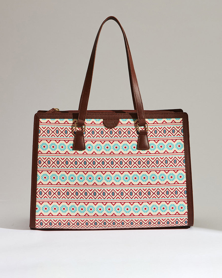 Front view of Aztec patterned office tote with brown vegan leather handles and trim against a plain backdrop