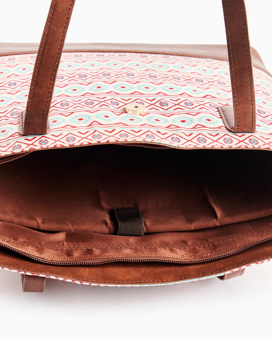 Close-up of interior showing padded laptop compartment and multiple pockets inside Aztec tote
