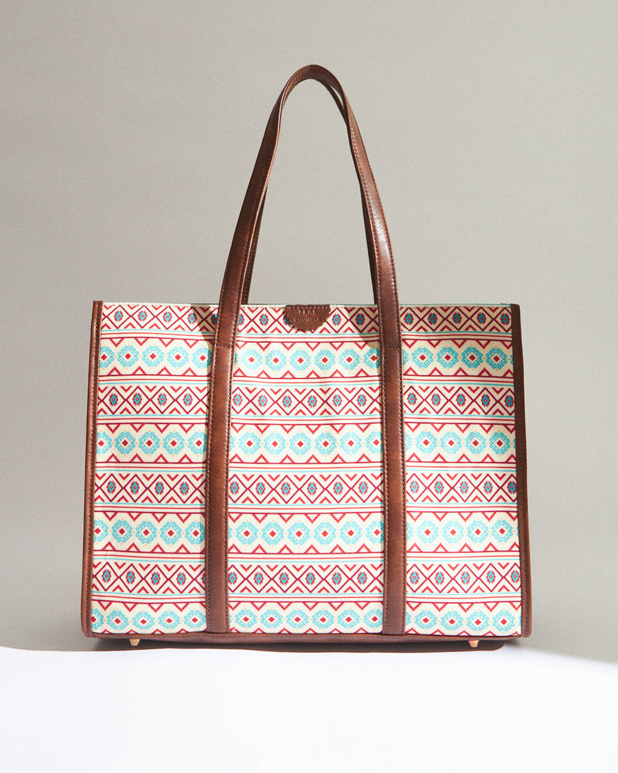 Front view of the Aztec pattern canvas tote bag showcasing vibrant red and teal geometric motifs with brown vegan leather trim