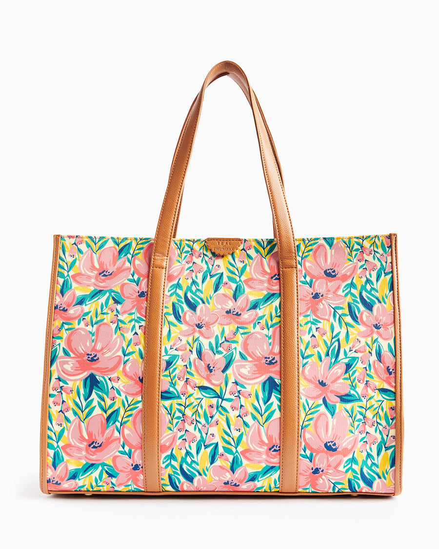 Bright floral canvas tote bag featuring large pink flowers and brown leather straps and trim
