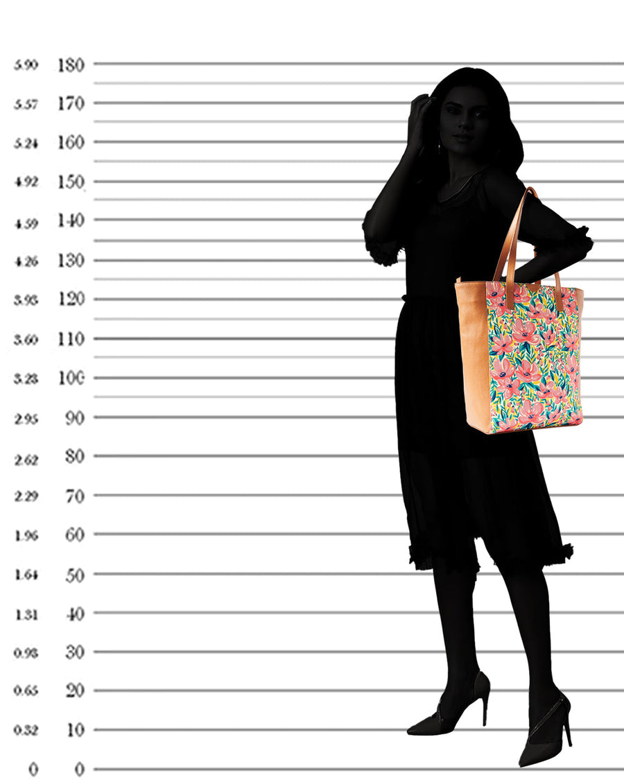 Silhouette of a woman holding the floral tote bag on her shoulder demonstrating bag size and proportions