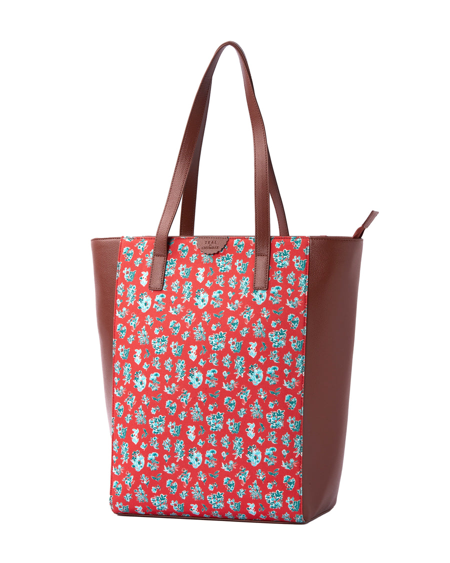 Side angle view of floral print tote bag showing the brown vegan leather and canvas body