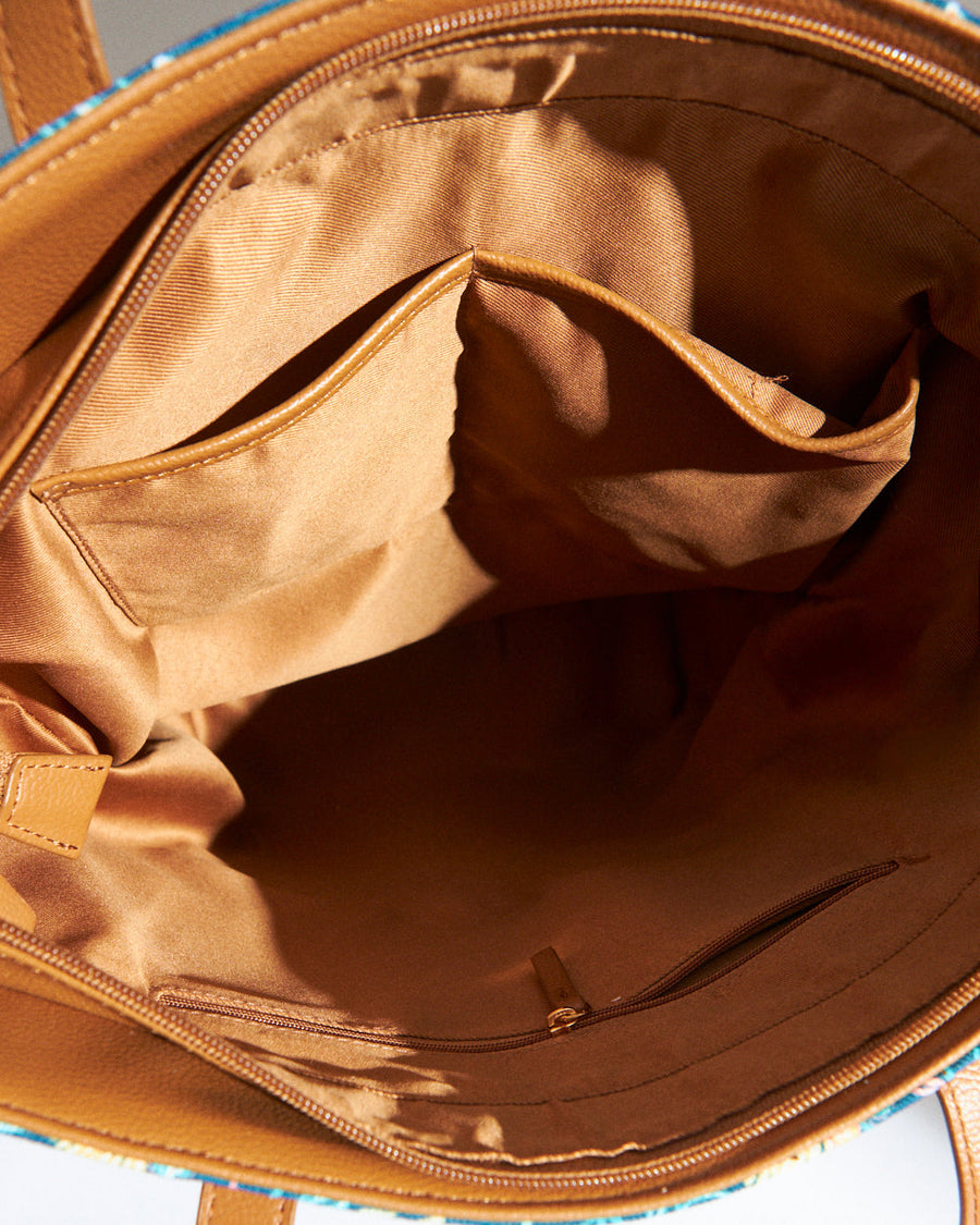 Full front view of camel vegan leather and floral print tote bag with double handles