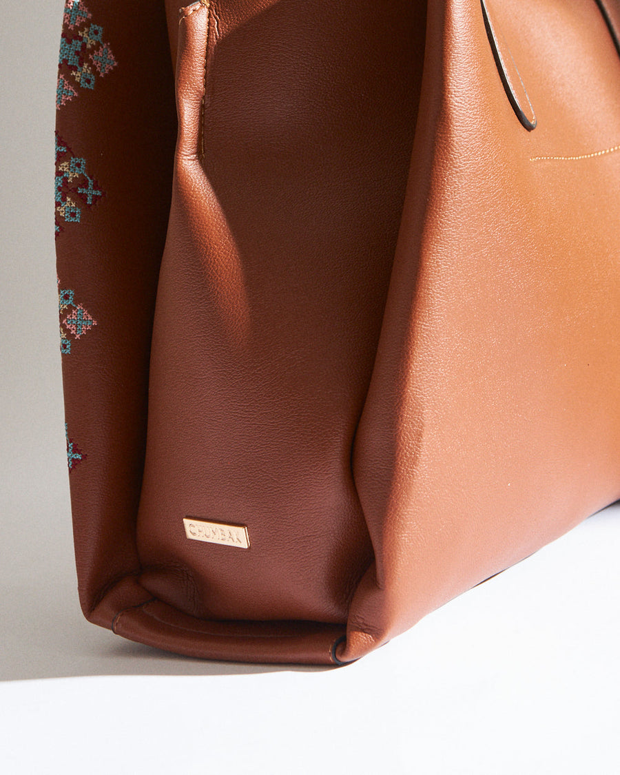 Interior view of the tote bag featuring beige fabric lining, zipper pocket, and a snap button closure