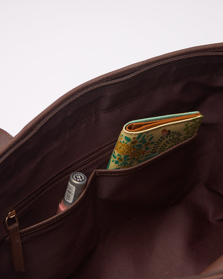 Close-up of Teal by Chumbak brand label on front of floral tote bag