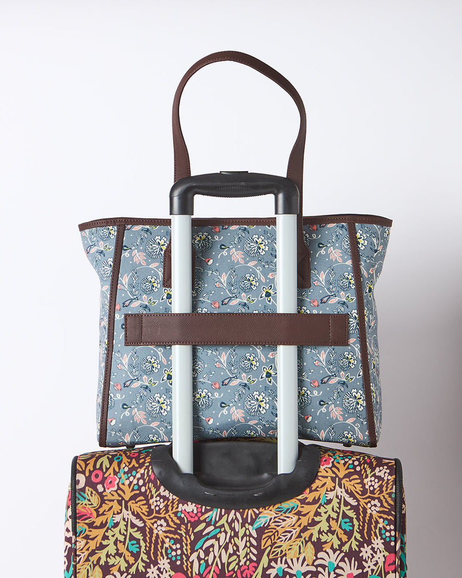 Floral tote bag attached to luggage handle using back trolley sleeve