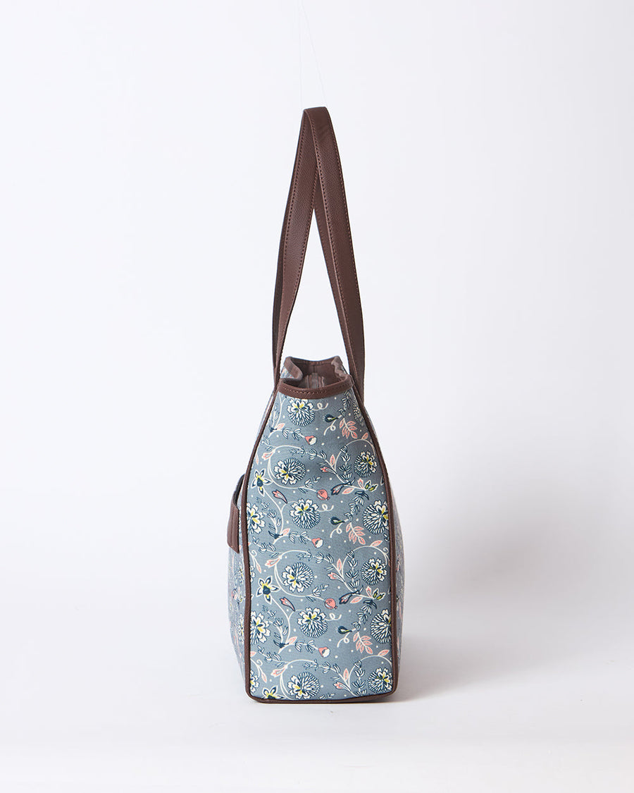 Side profile view of floral tote bag showing slim shape with brown trim