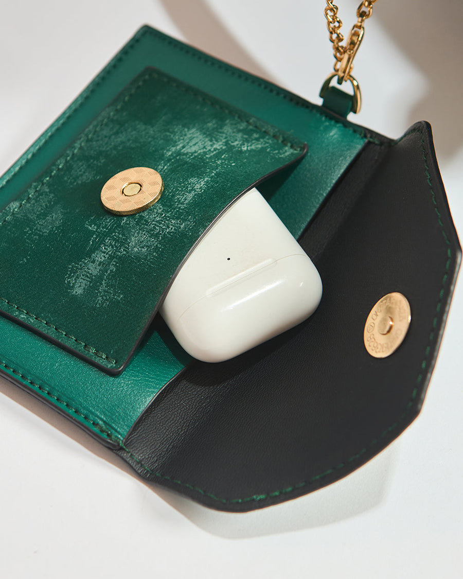 Mini emerald green pouch with snap button open revealing wireless earbud case inside