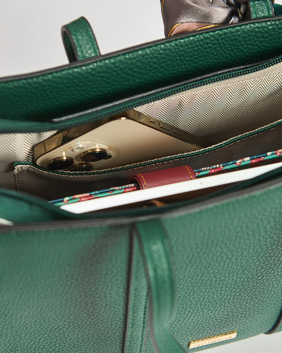 Close view of interior pocket holding a smartphone inside green mini tote bag