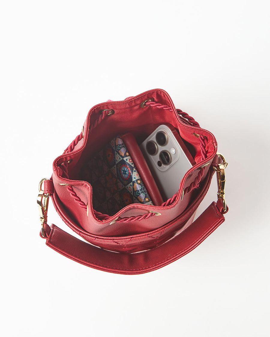 Top view inside bucket bag showing spacious compartment holding wallet and smartphone