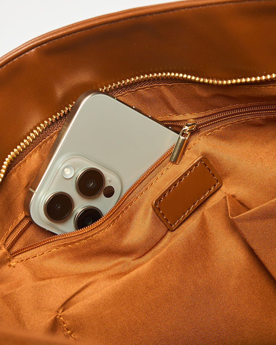 Close-up showing zipper pocket inside the tote containing a smartphone
