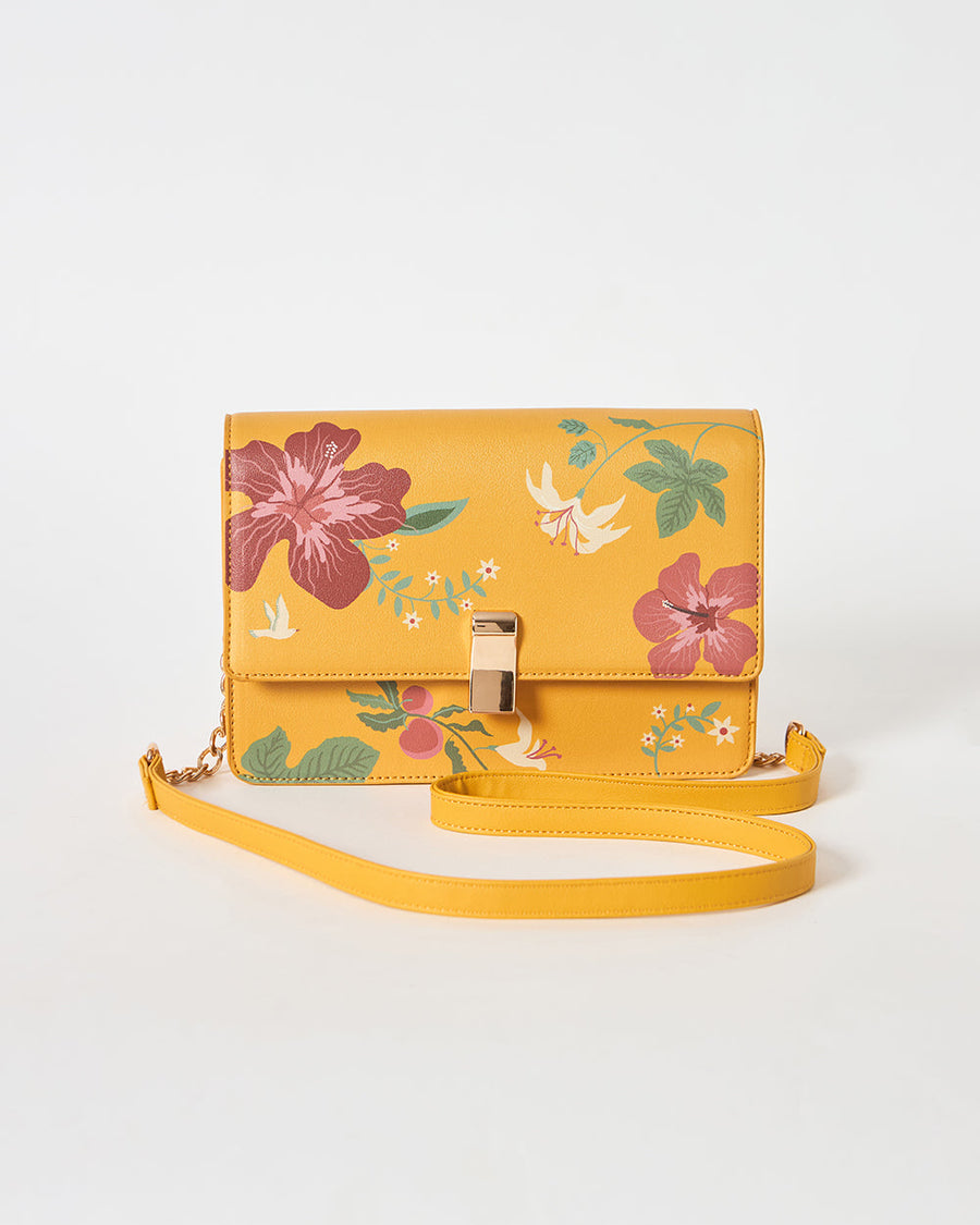 Side view of mustard yellow floral shoulder bag with an adjustable sling strap on white background