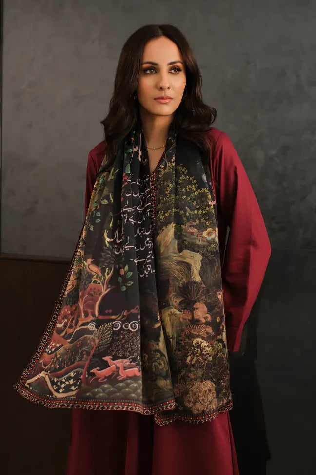 Woman wearing a rich maroon outfit with a black crinkle silk scarf featuring intricate embroidery of floral, animal motifs, and Allama Iqbal calligraphy