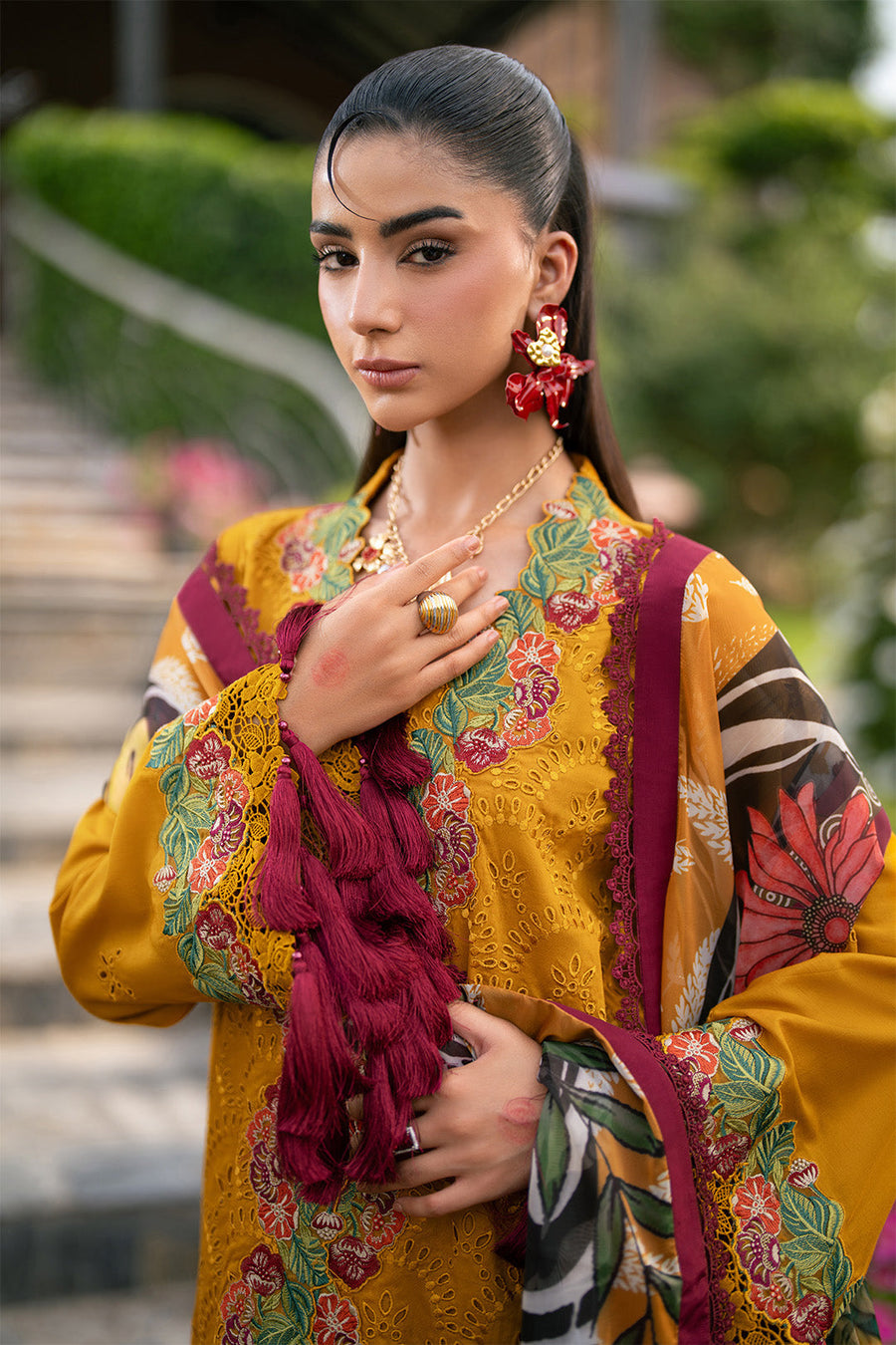 Three-quarter front view of full traditional lawn suit with embroidered sleeves and floral embroidery on hem