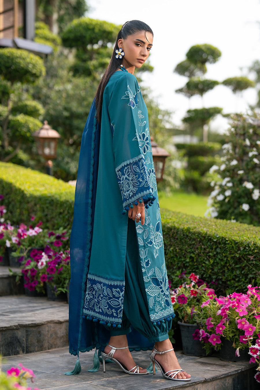 Side view of embroidered lawn suit showing intricate sleeve and border embroidery with pompom accents